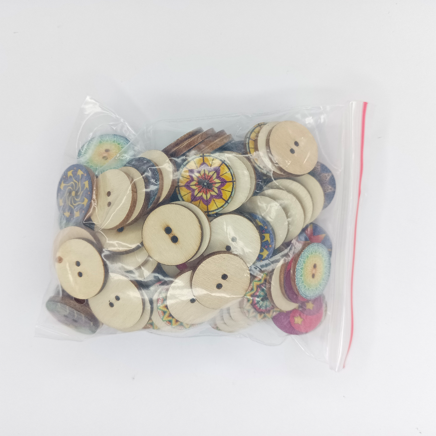 Bag of assorted buttons with colorful designs on a white background