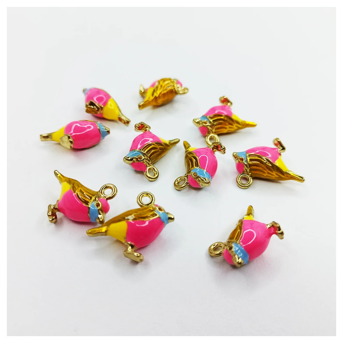 Pink and gold bird-shaped charms on a white background