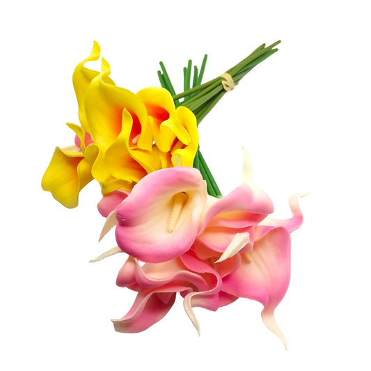 Two bunches of artificial calla lilies on a white background. One bunch is yellow with orange-red gradients, and the other is pink with cream gradients, both with green stems.