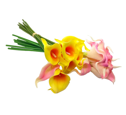 A bouquet of artificial calla lilies with green stems, featuring bright yellow flowers with orange centers and pink-and-white flowers, arranged on a white surface.