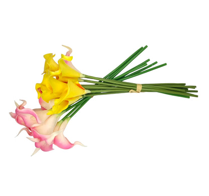 A bouquet of artificial calla lilies arranged diagonally on a white background. The flowers include yellow, pink, and peach blooms with long green stems tied together with a small beige band.