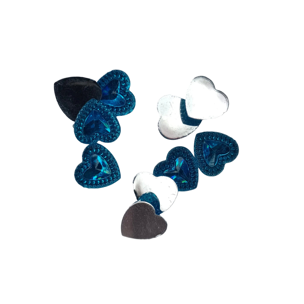 A small cluster of heart-shaped sequins in metallic blue, black, white, and silver, arranged on a plain white background.