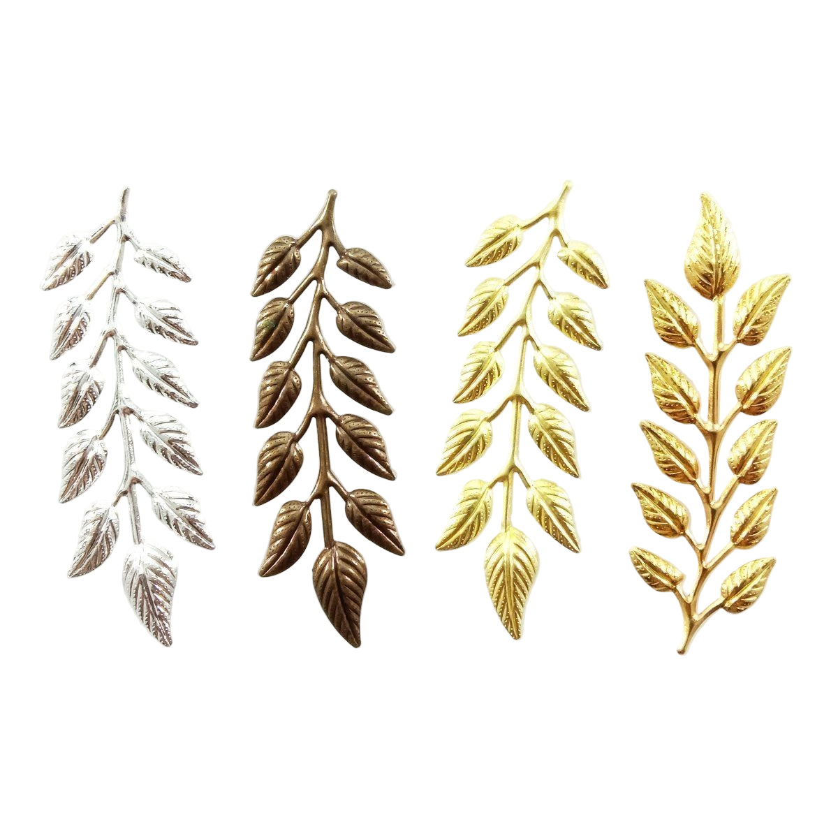 Set of leaf-shaped decorative items in silver, bronze, gold and brass colours on white background