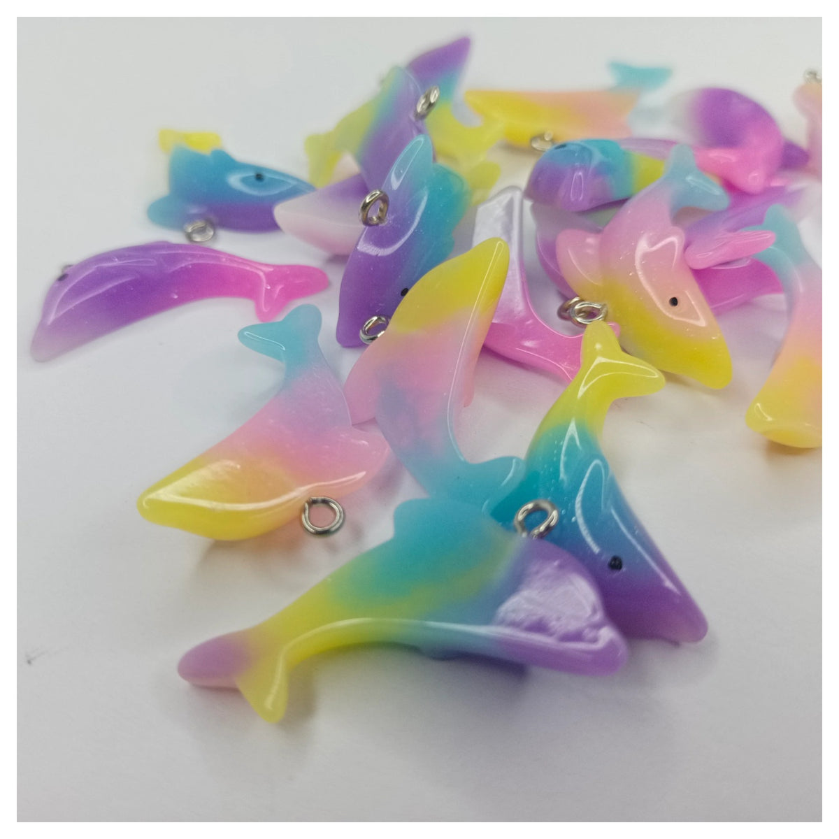 Colorful dolphin-shaped charms on a white background