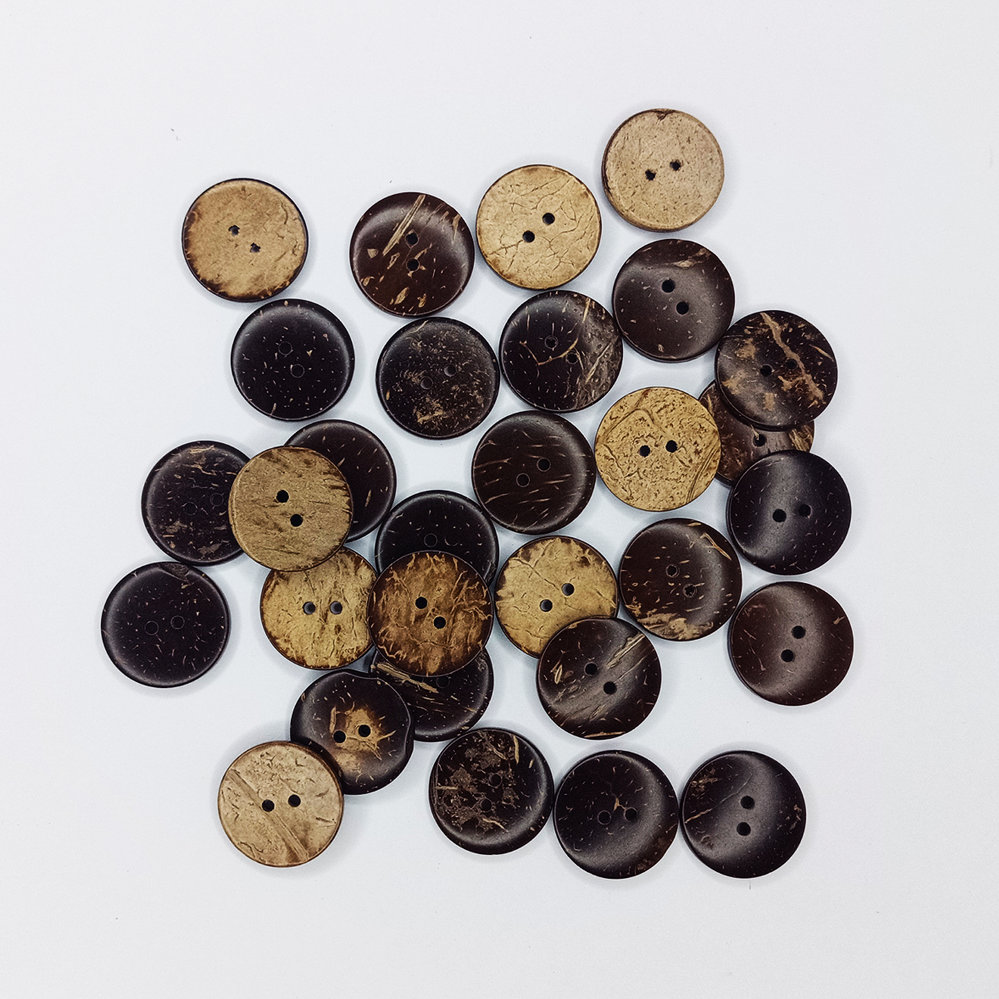 Collection of coconut shell buttons in various shades on a white background