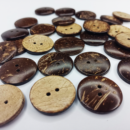 Collection of coconut shell buttons in various shades on a white background