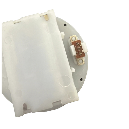 Close-up of the underside pins of a white plastic round battery holder on a white background