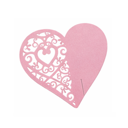 Pink heart-shaped cardboard wedding table placeholder with intricate cutouts on a white background