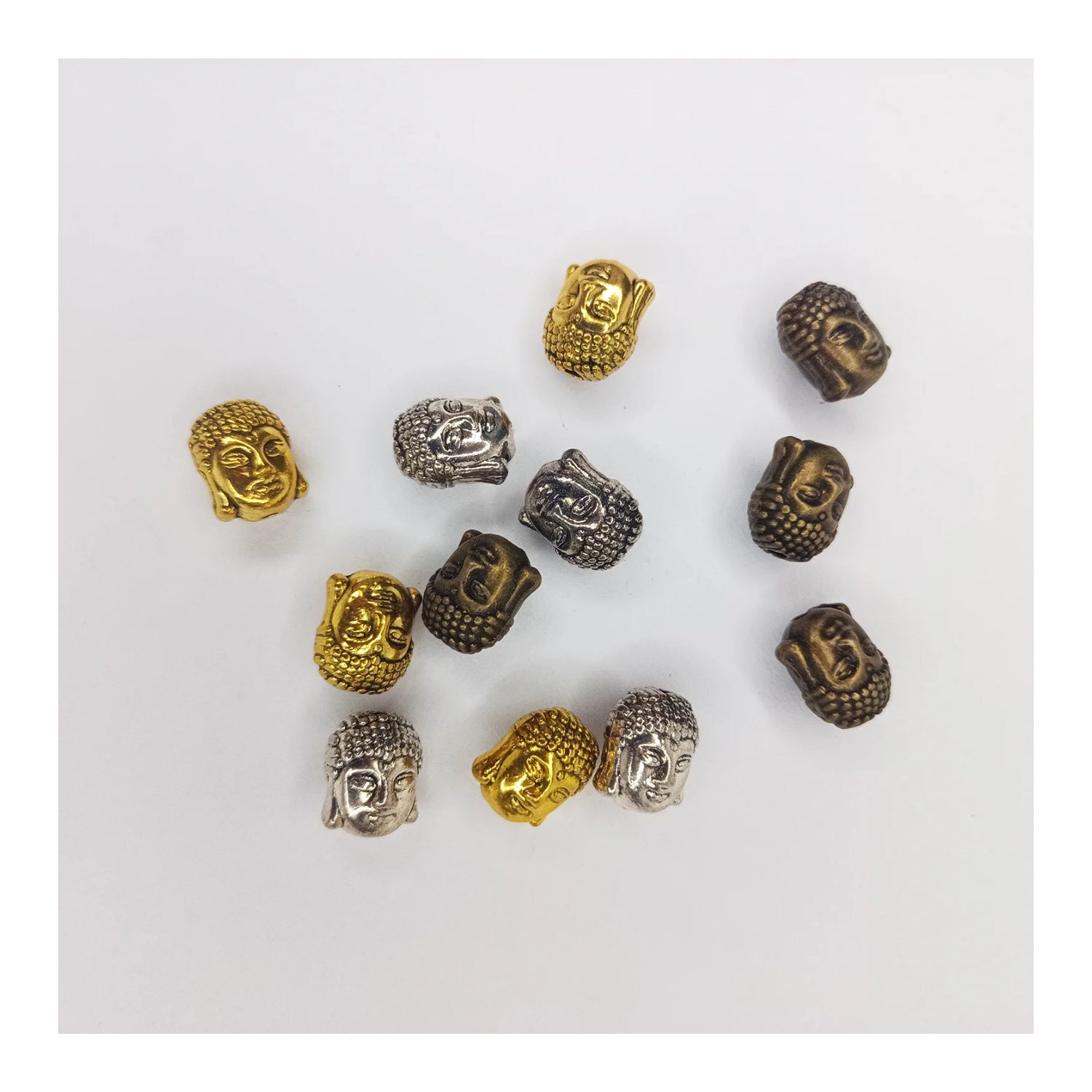 Metallic Buddha head beads in gold, silver, and bronze on a white background