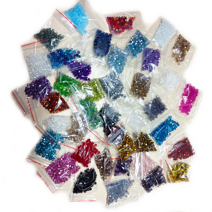 Assorted colored crystals in small clear bags on a white background