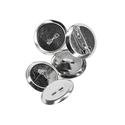 Five silver metal pin-back buttons shown from different angles on a light gray background, displaying both the front button face and the back safety pin clasp mechanism.