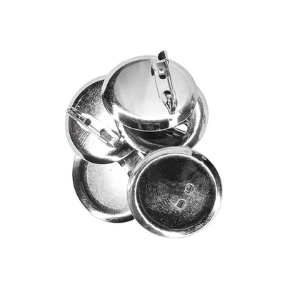 A pile of round metallic silver pin-back buttons, showing both the shiny front metal surfaces and the reverse side with pin clasp hardware, set against a plain white background.