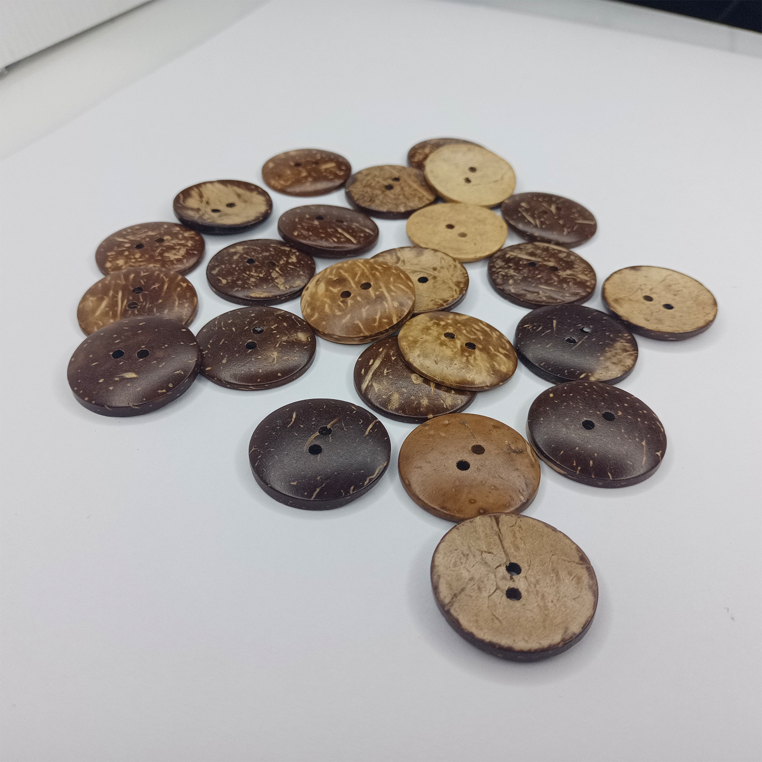 Collection of brown and beige buttons on a white surface