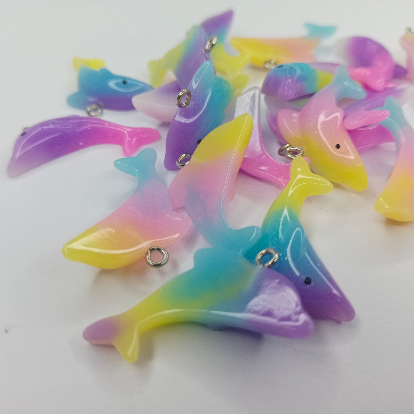 Colorful dolphin-shaped charms on a white background