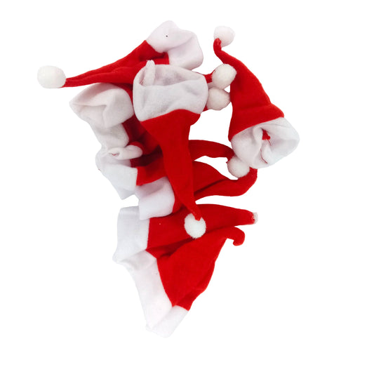 A pile of small red and white Santa hat accessories with white pom-poms, arranged on a plain white background.