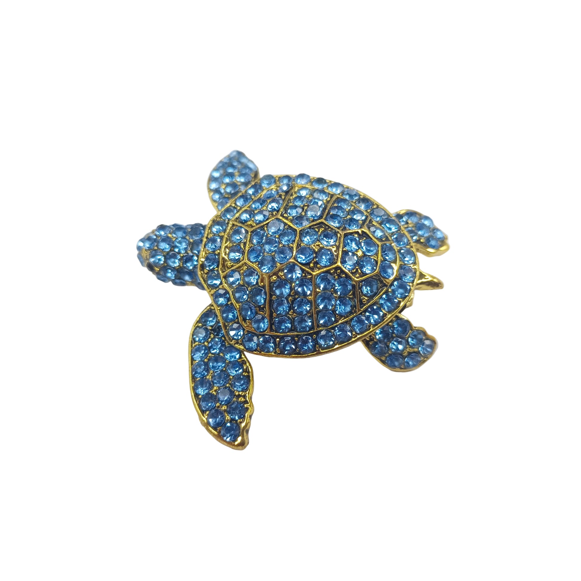 Tortoise-shaped brooch with blue gemstones on a white background