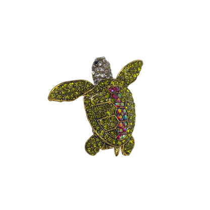 Tortoise-shaped jewelry with gemstones on a gray background