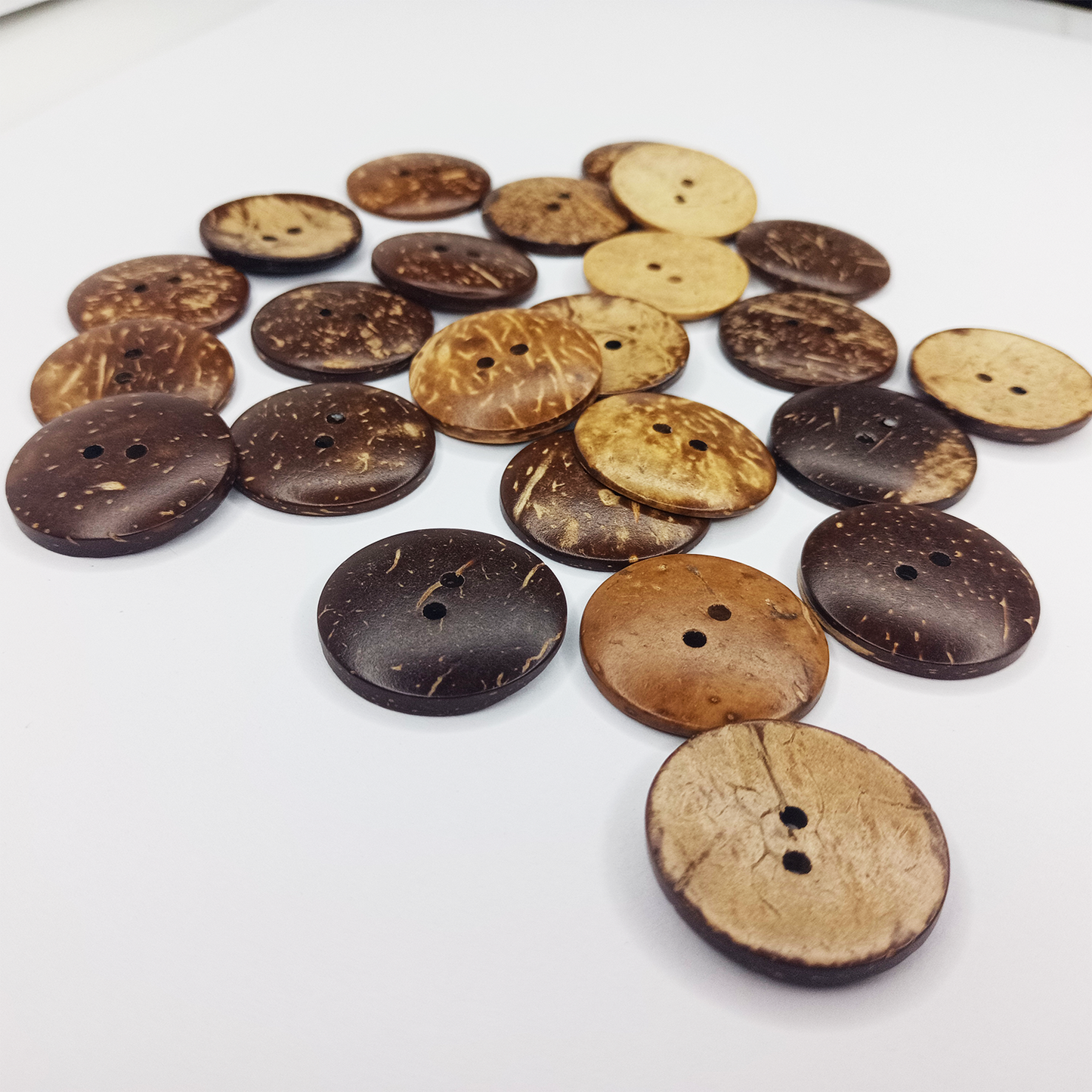 Collection of coconut buttons in various shades on a white background