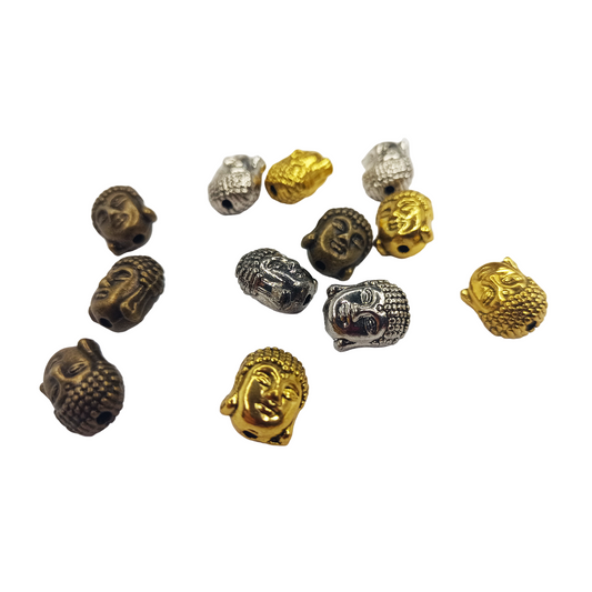 Collection of gold, silver, and bronze Buddha head beads on a white background