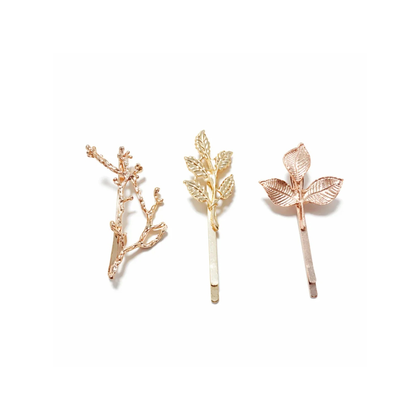 Three gold hair pins with leaf and branch designs on a white background