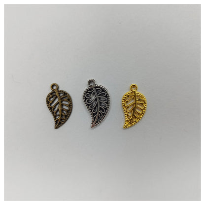 Three leaf-shaped charms in bronze, silver, and gold on a white background