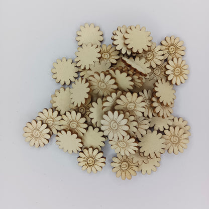 A pile of small natural wood daisy-shaped craft embellishments on a plain light gray background.